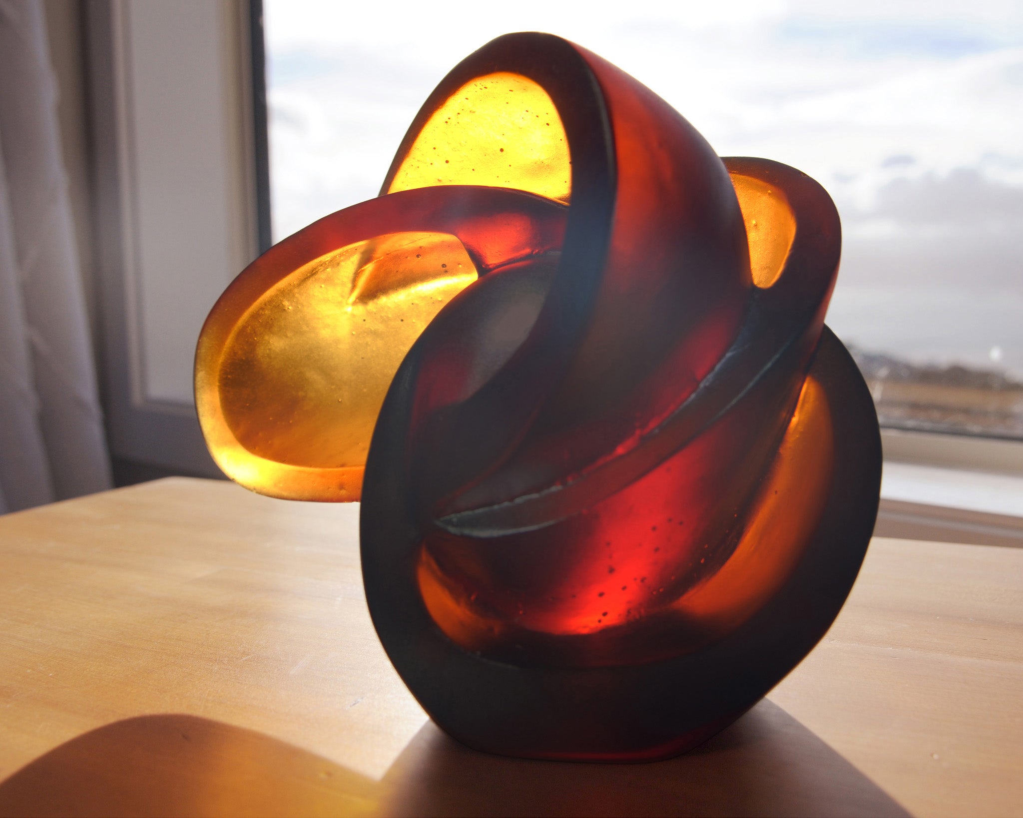 Abstract geometric cast glass sculpture of the atom by Stephen Williams.
