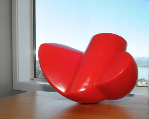Twist - Red plastic lamp sculpture in daylight by Stephen Williams